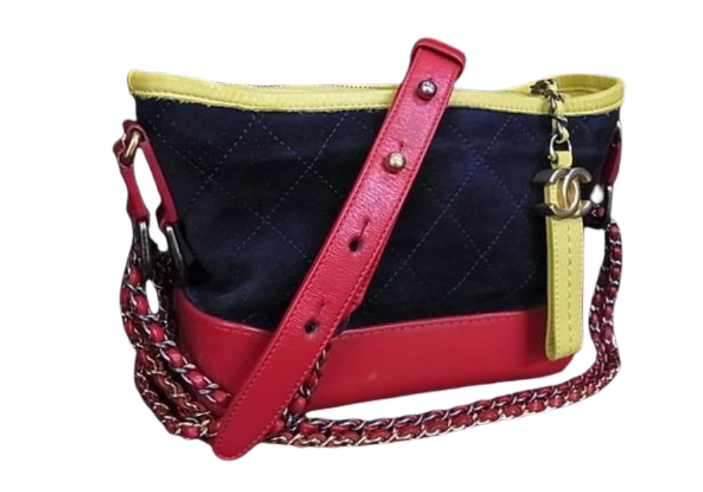 Red and navy quilted crossbody bag with yellow trim and red strap, featuring a chain accent and front pocket detail