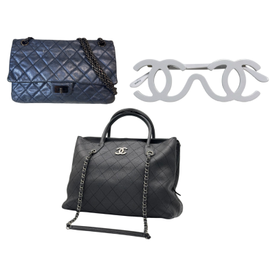 Blue quilted Chanel handbag with chain strap, white interlocking CC sunglasses, and a black quilted Chanel tote with chain handles.